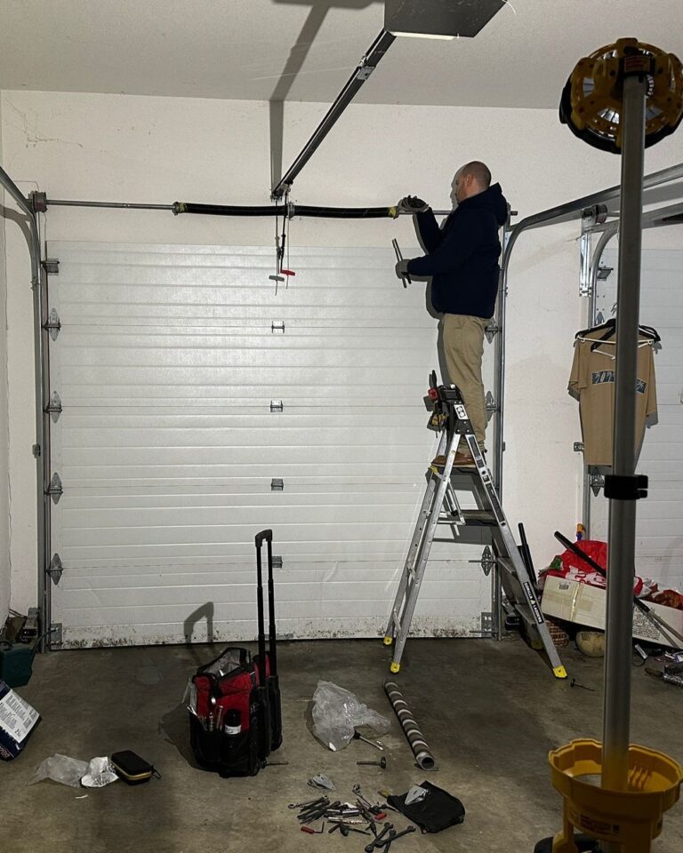 a garageDoorMaster technician installing a garage door spring