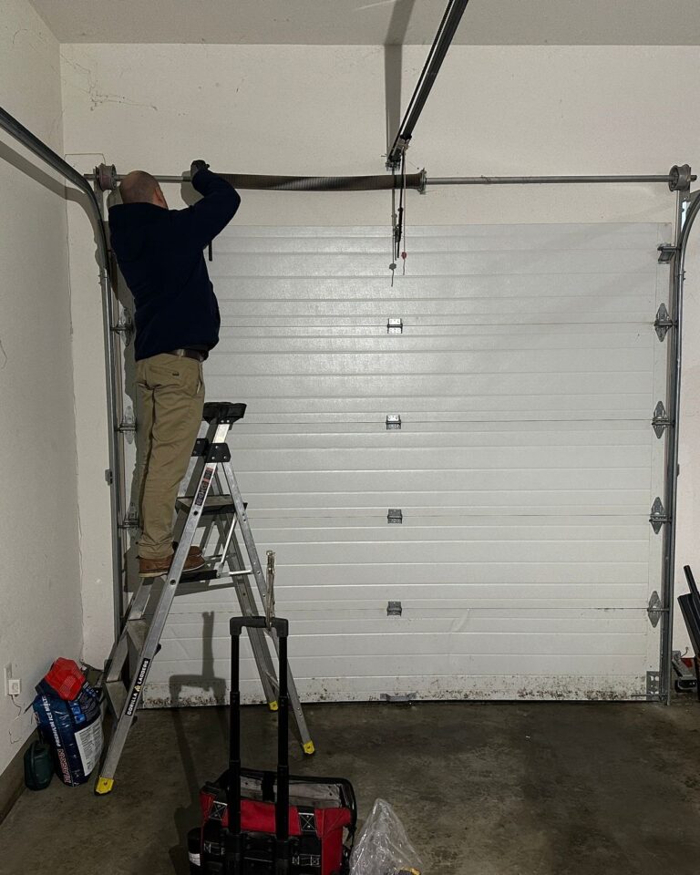 a garageDoorMaster technician installing a garage door spring